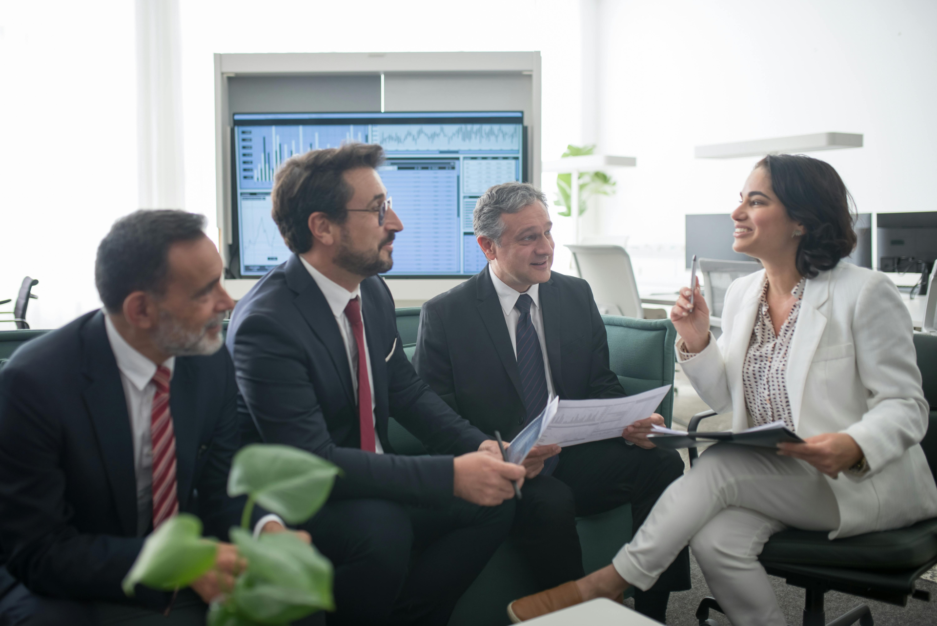 3 men in suits and a woman sitting